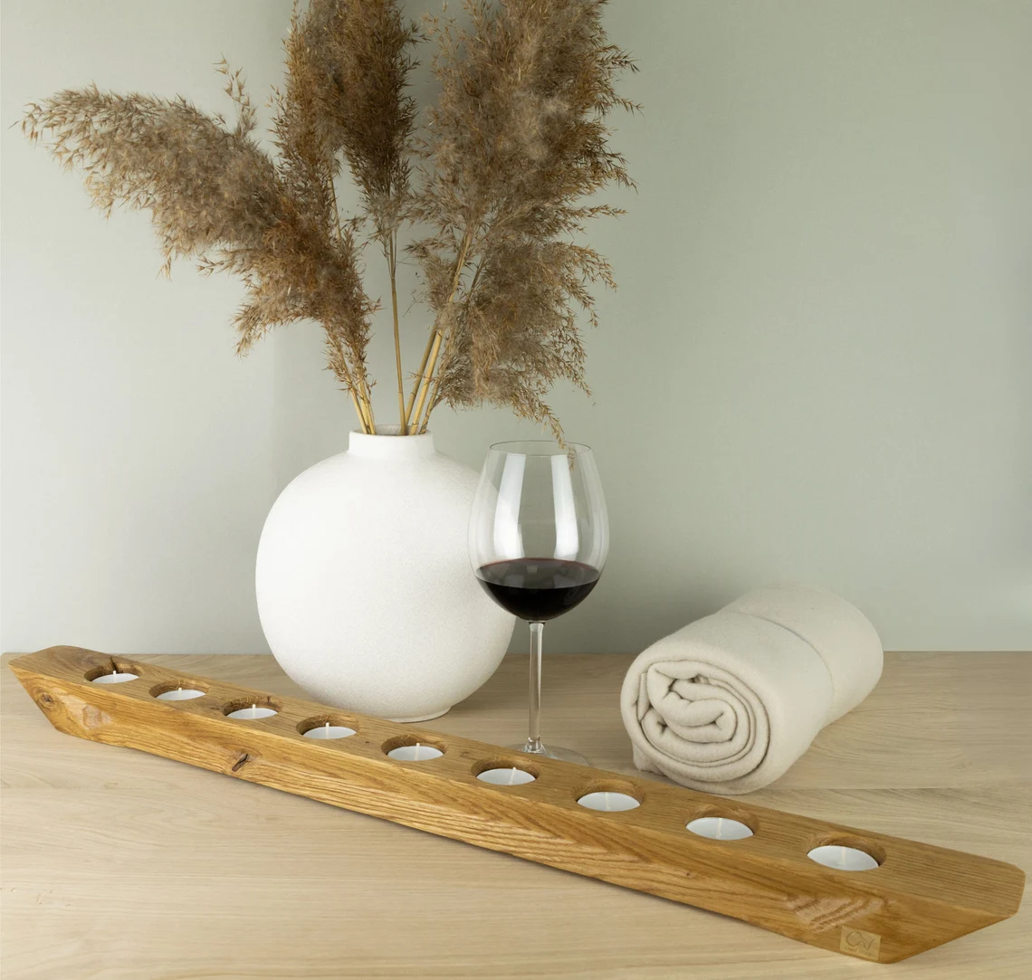 Rustikaler Eichen-Kerzenständer neben einem Weinglas auf einem Tisch