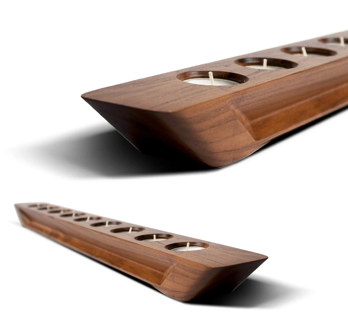 GLARE Kerzenständer aus amerikanischem Nussbaum, neben einer dekorativen Pflanze.