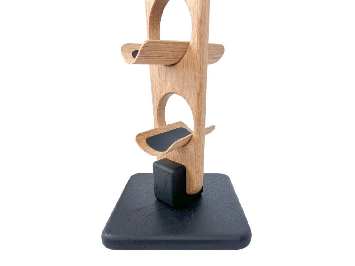 Nahaufnahme des Sockels des TWINE-Weinregals aus Eichenholz auf einer schwarzen Basis für maximale Stabilität.