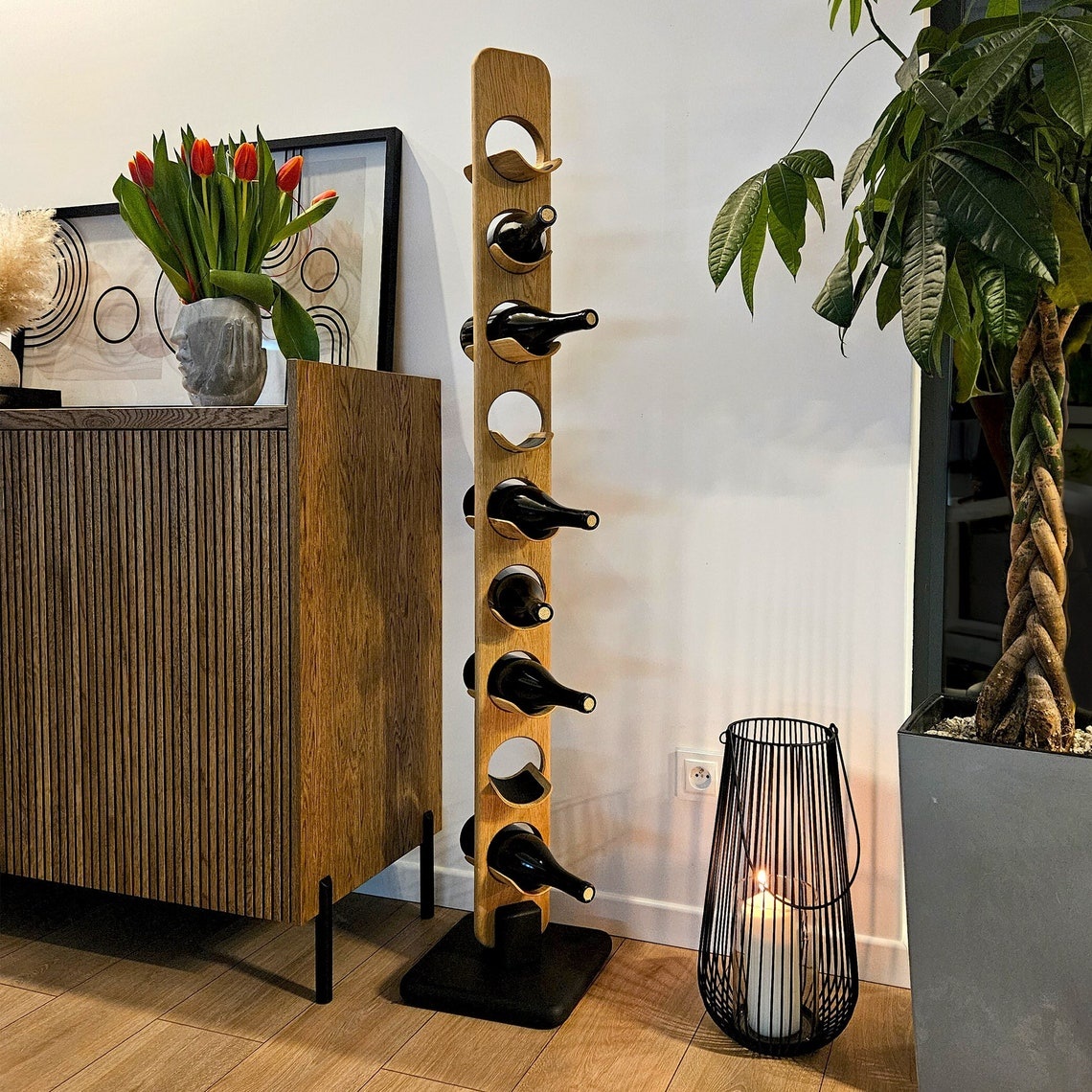 Das TWINE-Weinregal im Wohnzimmer neben einem Sideboard und einer Pflanze, elegant integriert in die Inneneinrichtung.