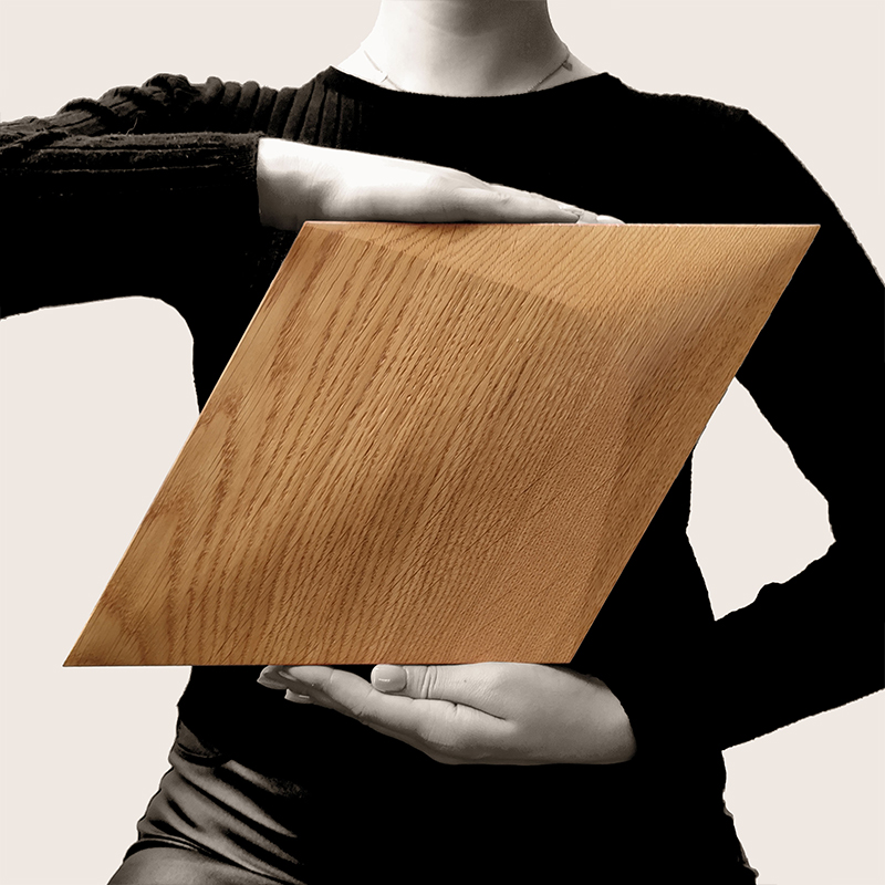 S01_Caro-plus_hand E02 Diamond Holzpaneel von Dekostyl, in der Hand gehalten, mit rautenförmigem Design und natürlicher Holzmaserung.